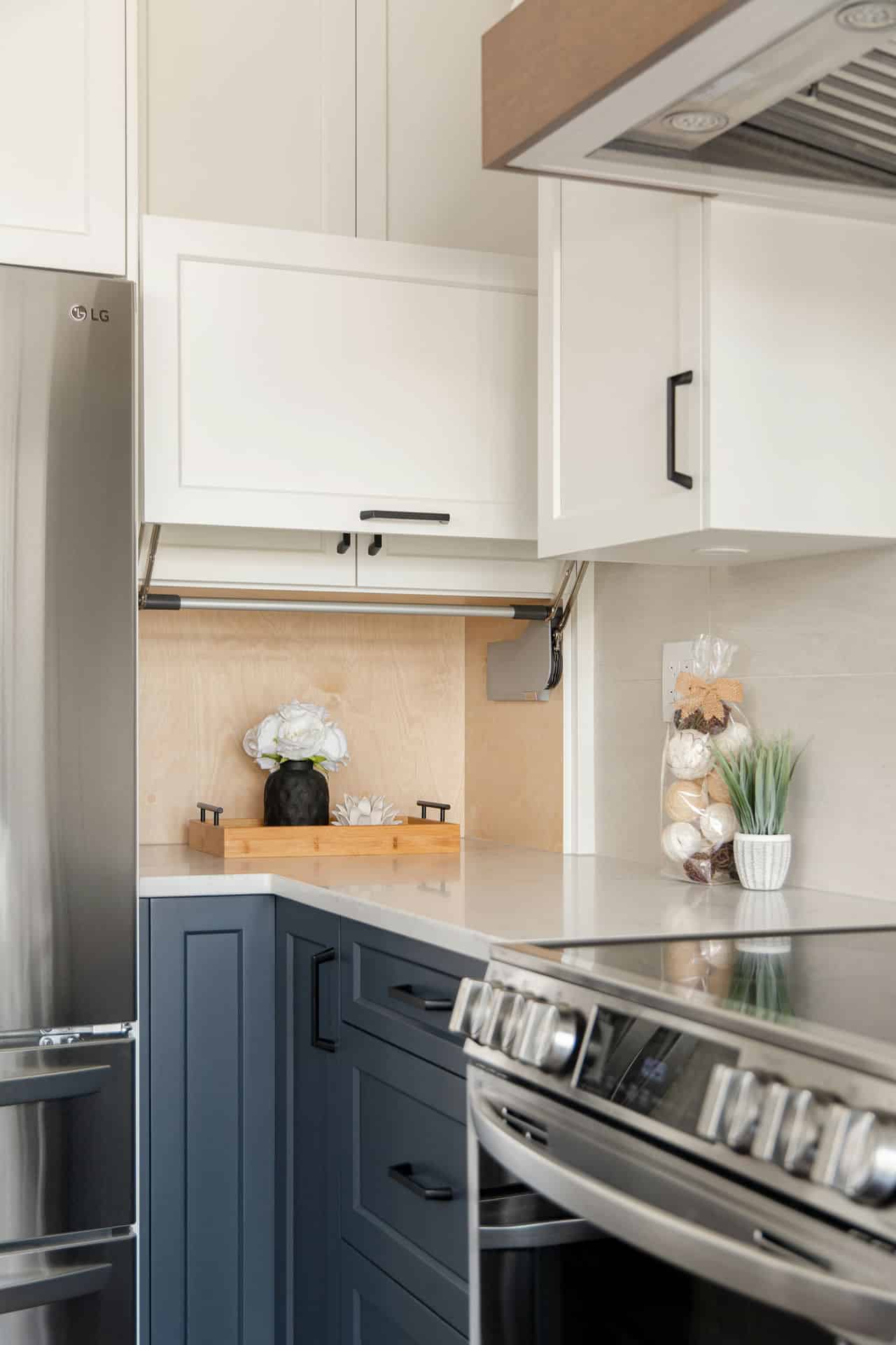 Stylish kitchen renovation featuring a two-tone cabinet design with navy lowers, white uppers, and a sleek quartz countertop