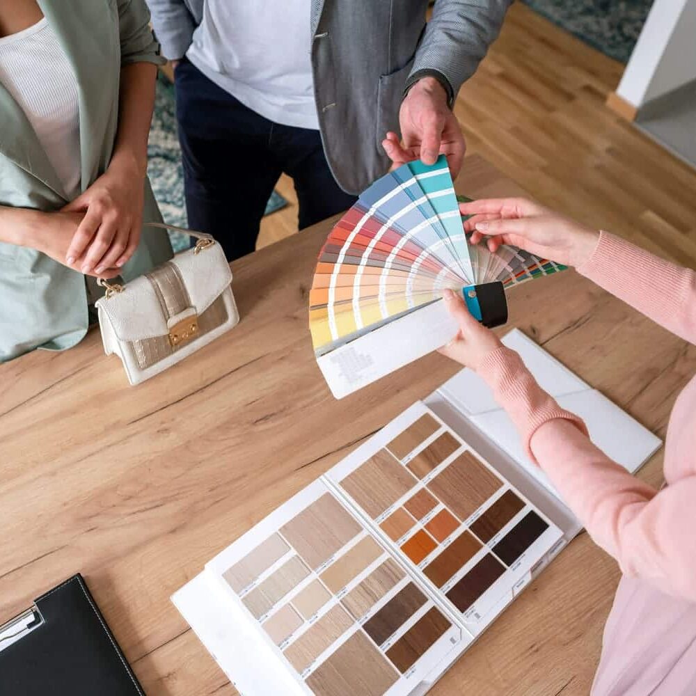 Interior design professionals reviewing fabric swatches and color palettes for a renovation project